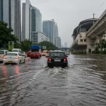 Flooded road in Gurgaon during heavy monsoon rain with vehicles moving through severe waterlogging.